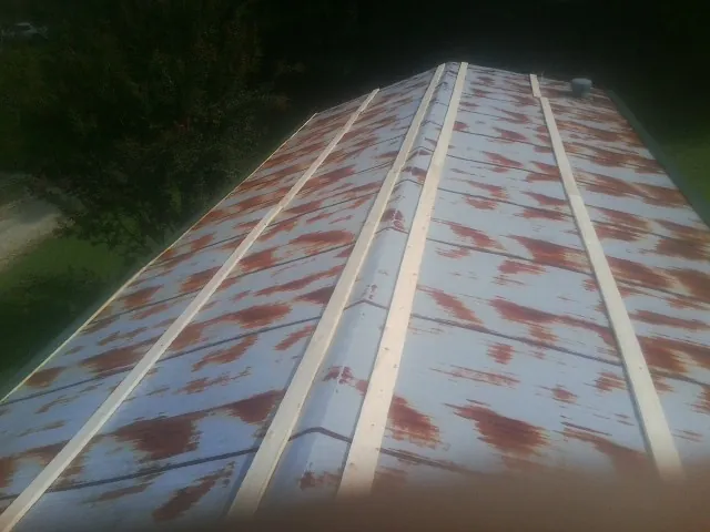 Rusted metal roof panels with new wood purlins before replacement — Storm Damage Roof Repair in Richmond Hill by Roofing Brothers