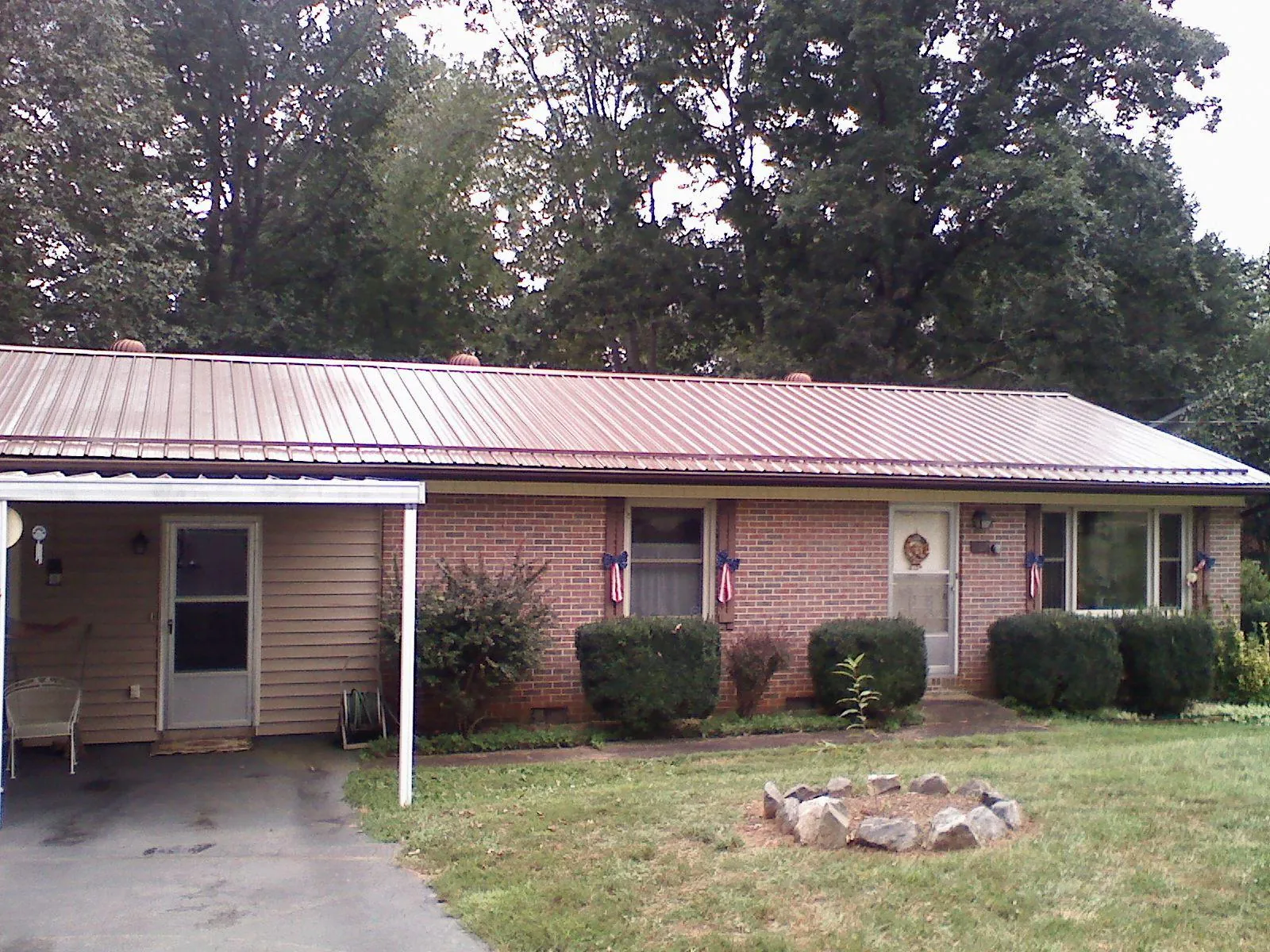 Bronze metal roof and carport on a brick ranch home — Roof Repair work by our crew in Richmond Hill